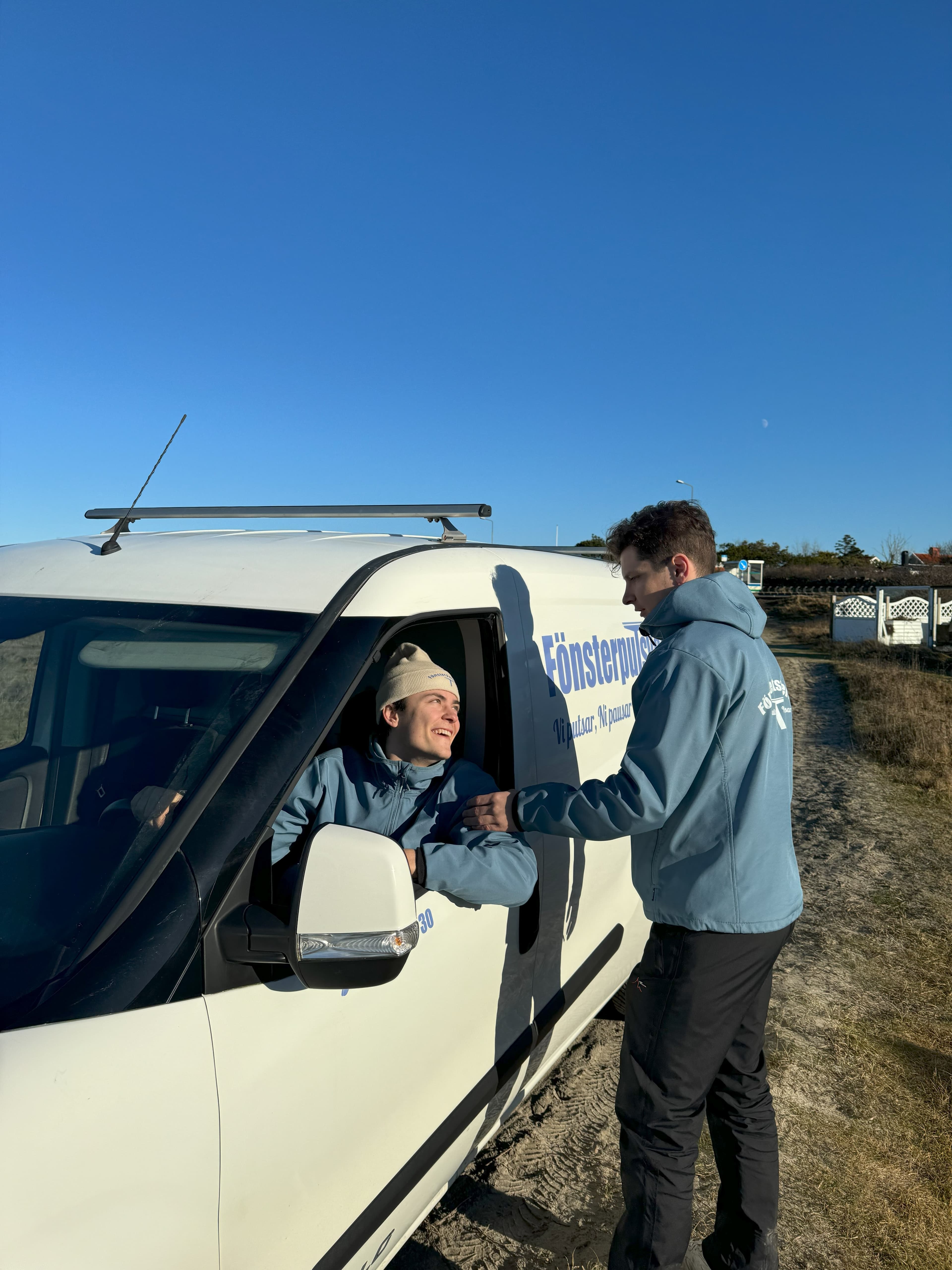 Två medarbetare vid förarplatsen i Fönsterputsverkets servicebil