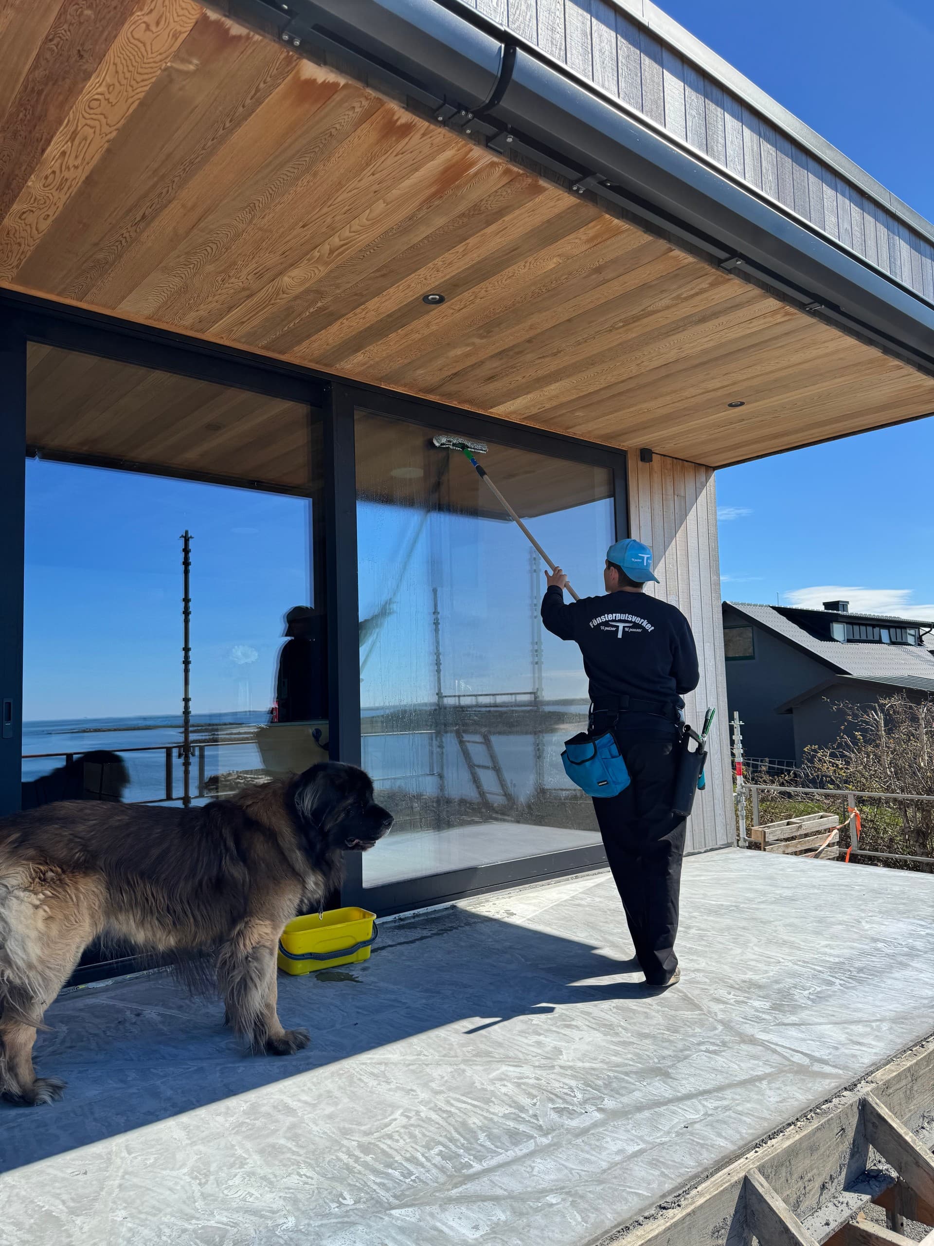 Fönsterputsare rengör stora fönster från en terrass